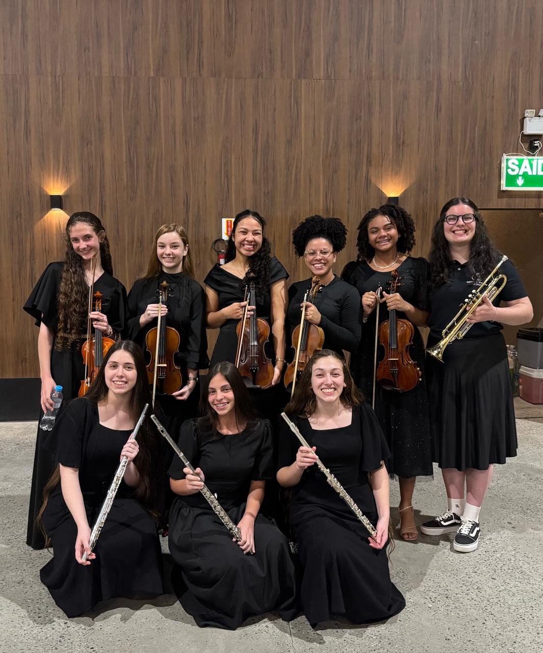 Musicistas da orquestra com violinos, flautas e trompete em Balneário Camboriú.