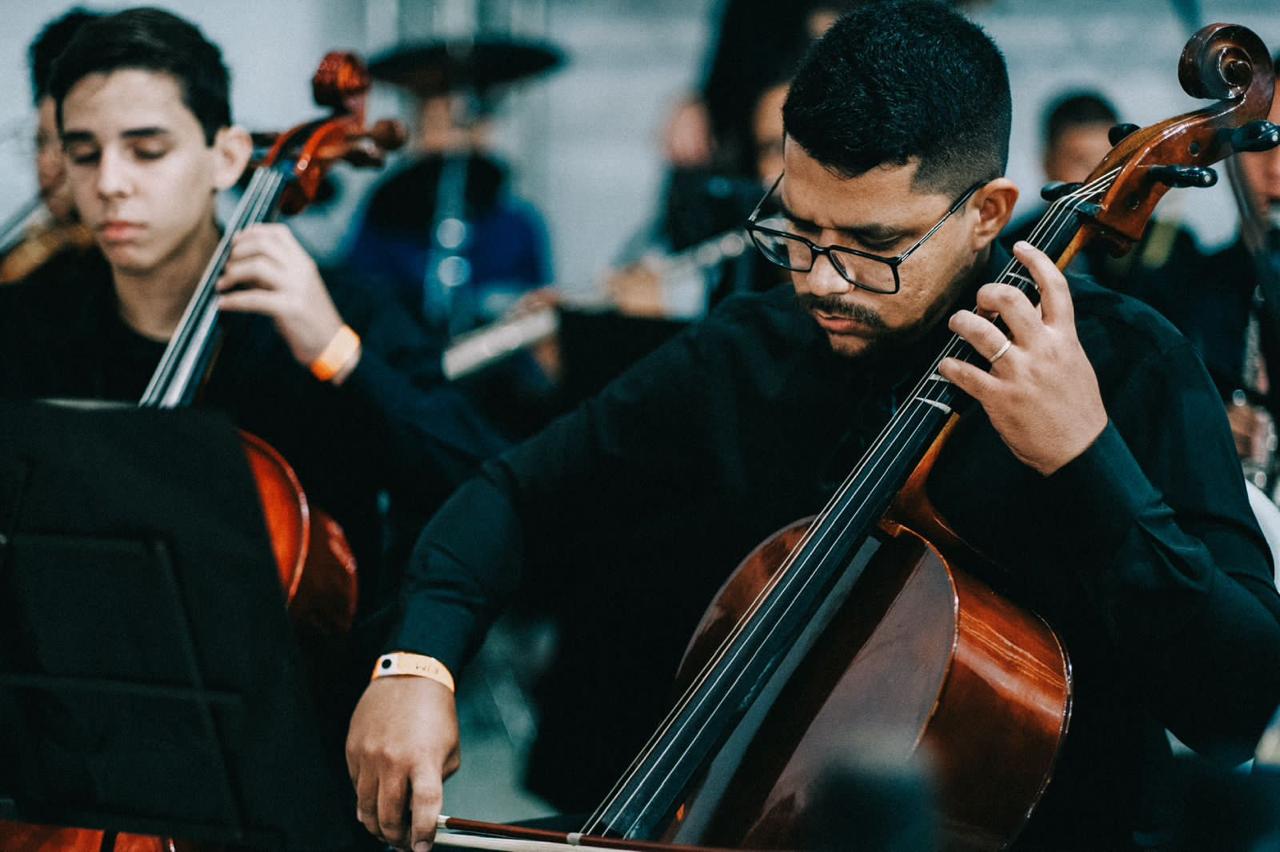 Violoncelistas da orquestra tocando durante o encontro em Porto Alegre.