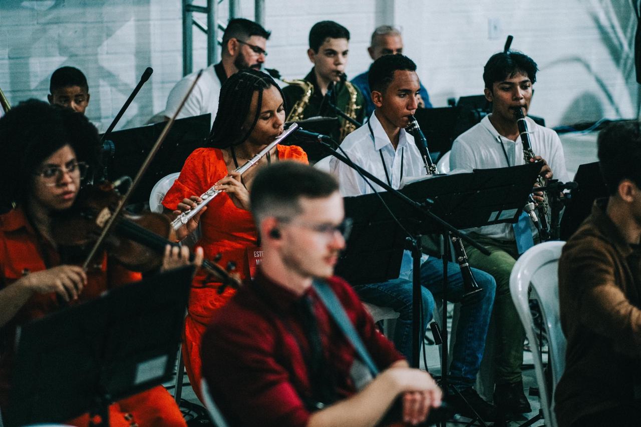 Músicos tocando violino, flauta e clarinetes no encontro em Porto Alegre.
